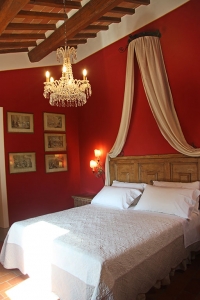 Letto a baldacchino e pareti rosse per la camera matrimoniale
